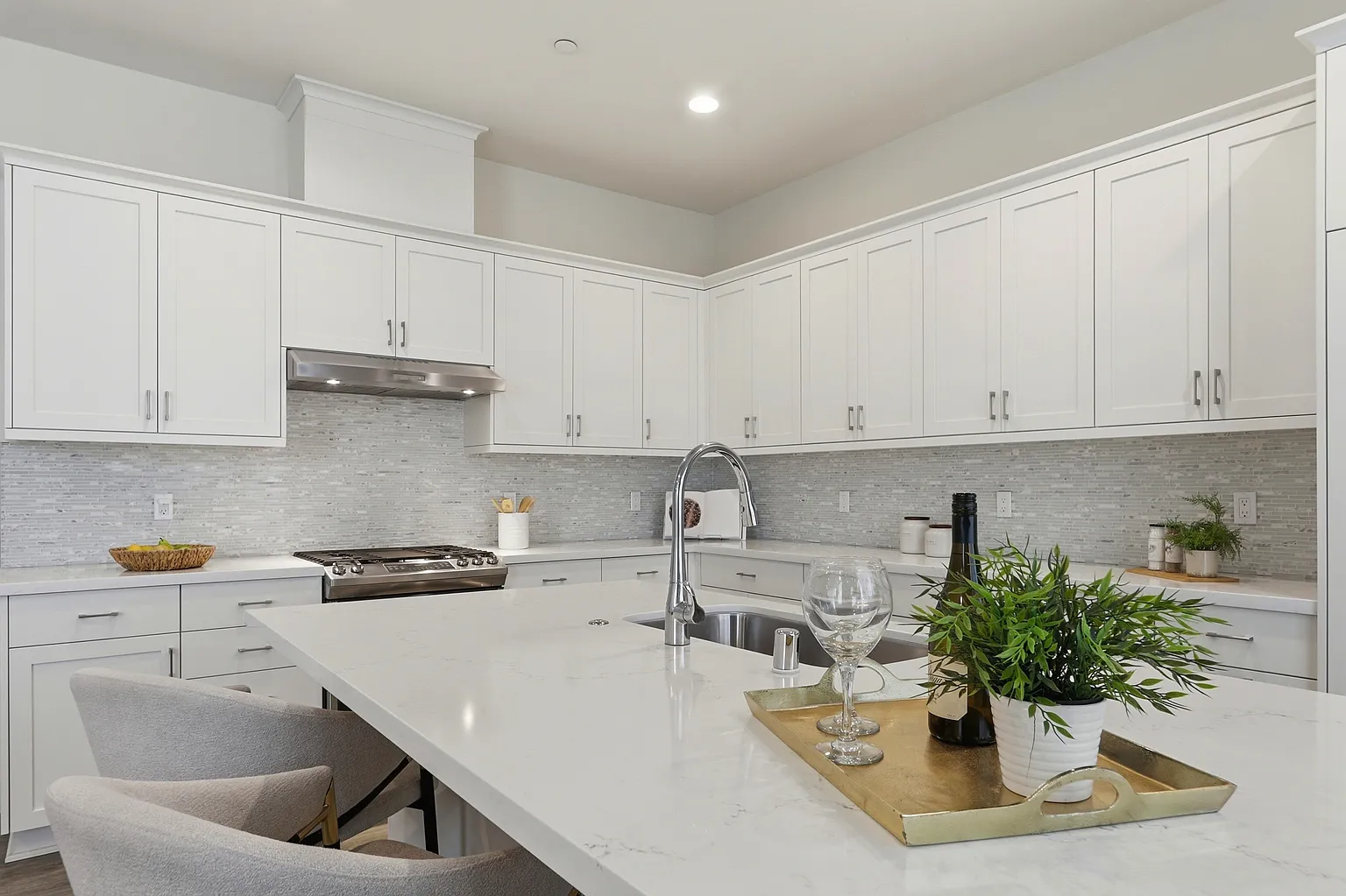 White kitchen with island, sink, and tile backsplash