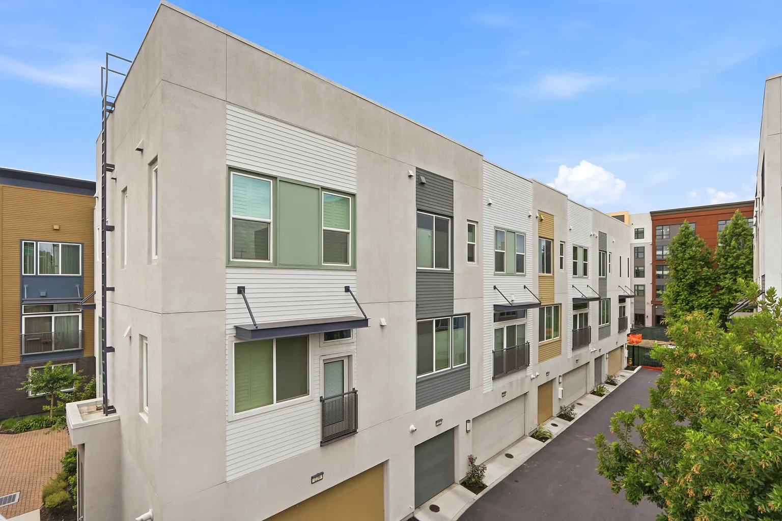 The row seen from above, sage and gold siding over the garage lane