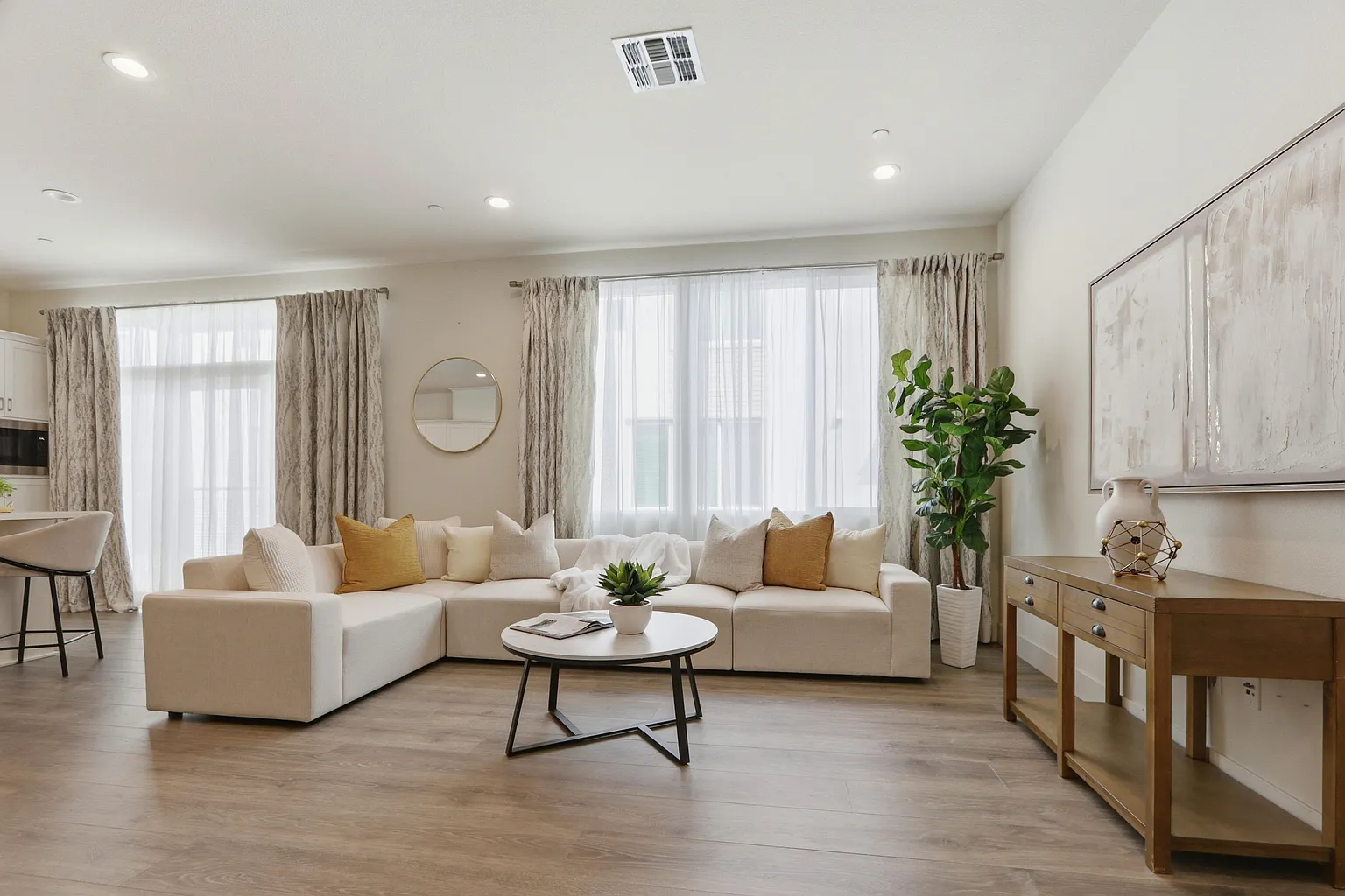 Living room with cream sectional and oak console under a large window