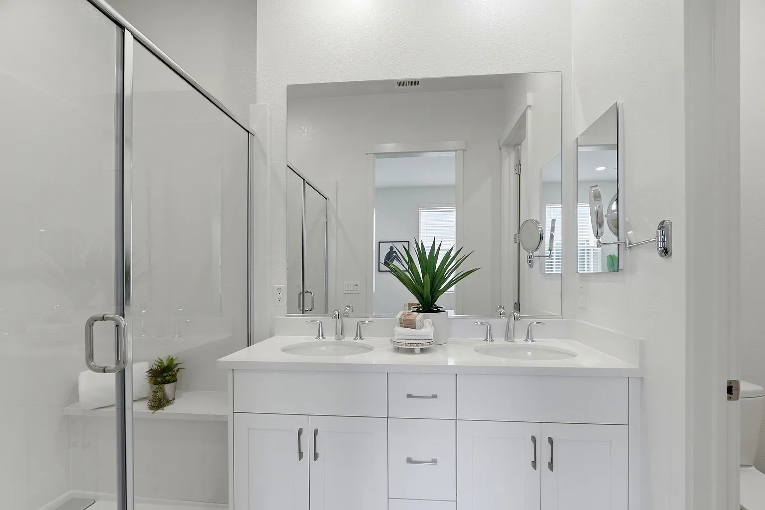 Primary bathroom with double vanity and glass shower